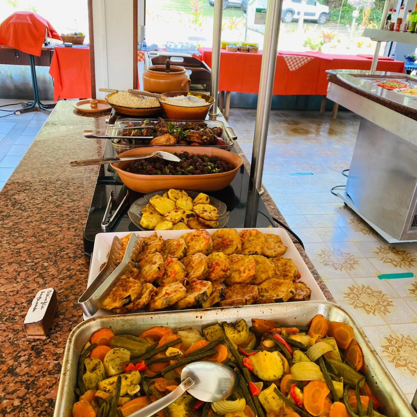 Buffet com alimentos e legumes apresentados pela pousada